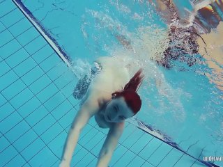 Redheaded Katrin stripping underwater