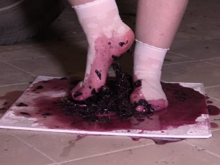 Plump legs in white socks mercilessly trample grapes. Crush fetish