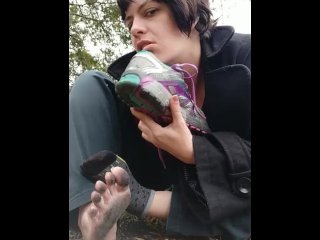 Takes off shoes and socks playfully and rubs sweaty feet in ash pit, spits and licks