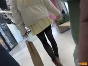 A girl walks in a short skirt without panties in a shopping mall